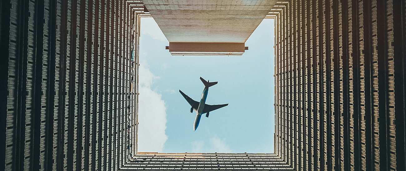 a plane flying over a building in Hong Kong